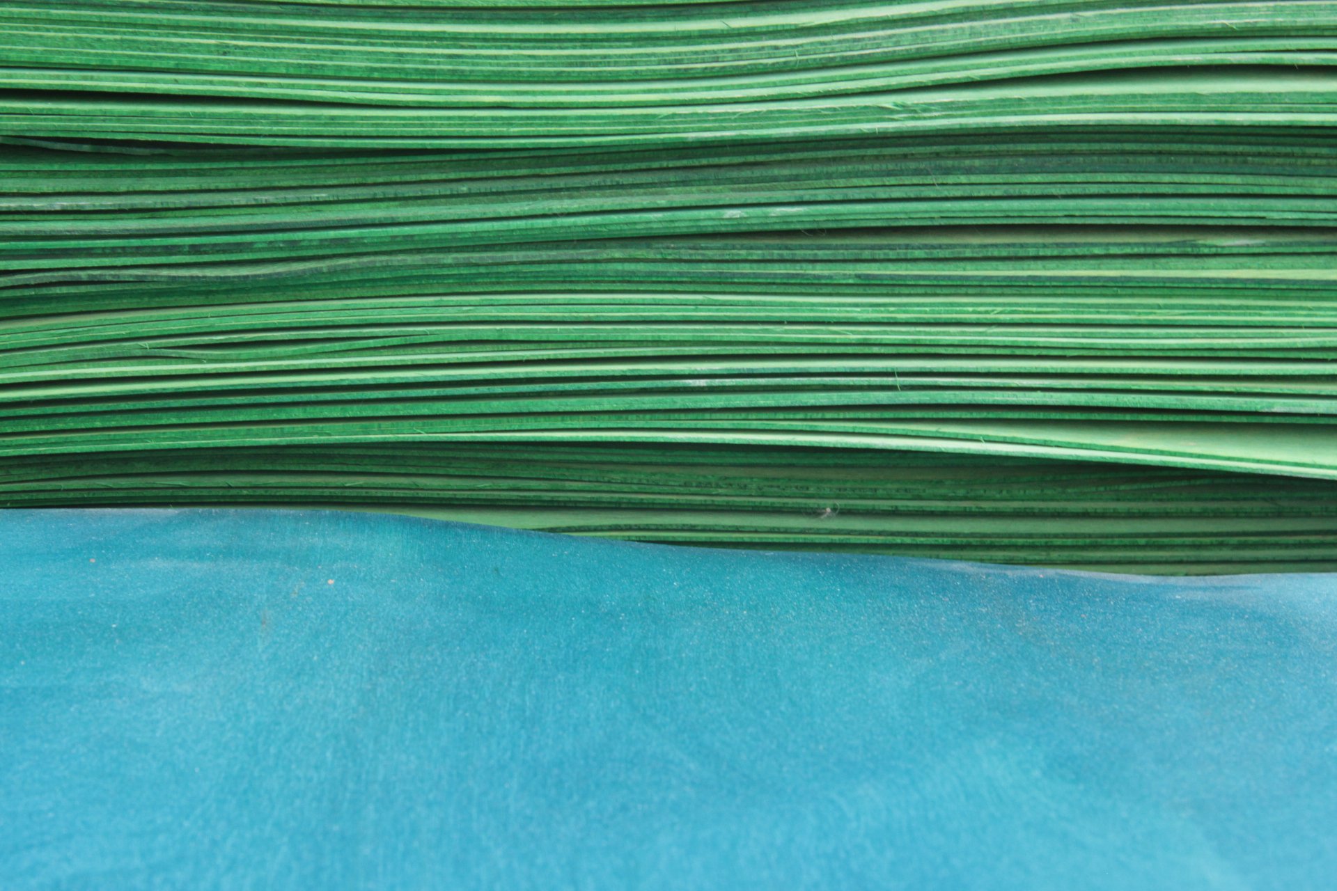 a stack of green skateboard veneers