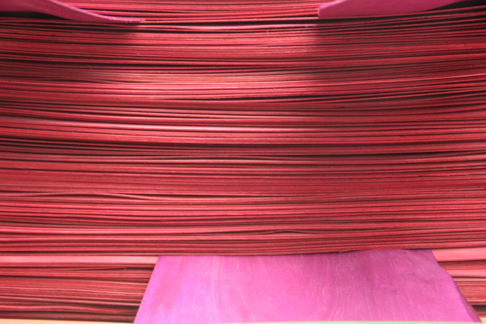 a stack of red skateboard veneers